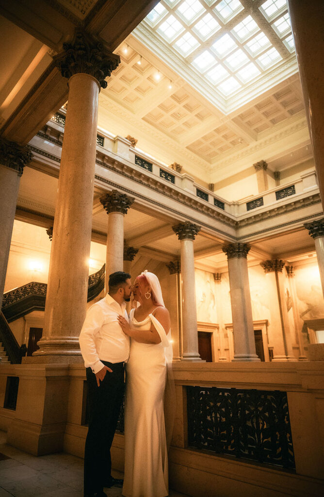 Bride and Groom walk up the grand staircase of Carnegie museum of art in Pittsburgh