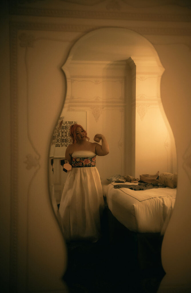 Bride Powdering herself while looking at herself in a mirror at Kimpton Hotel Monaco