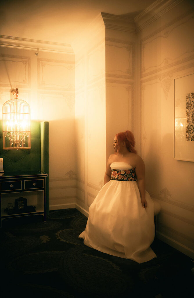 Bride looking away while sitting in Kimpton Hotel Monaco Room