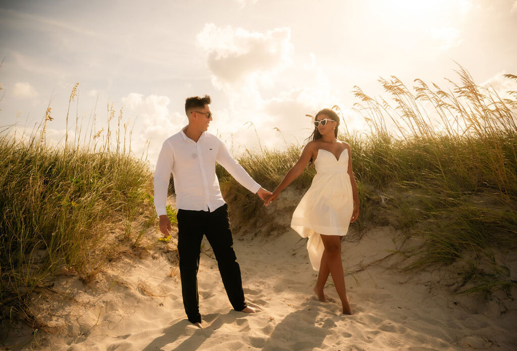 Couple walking down South Point Beach holding hands