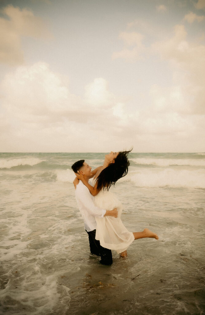 Engaged couple dancing in the Ocean