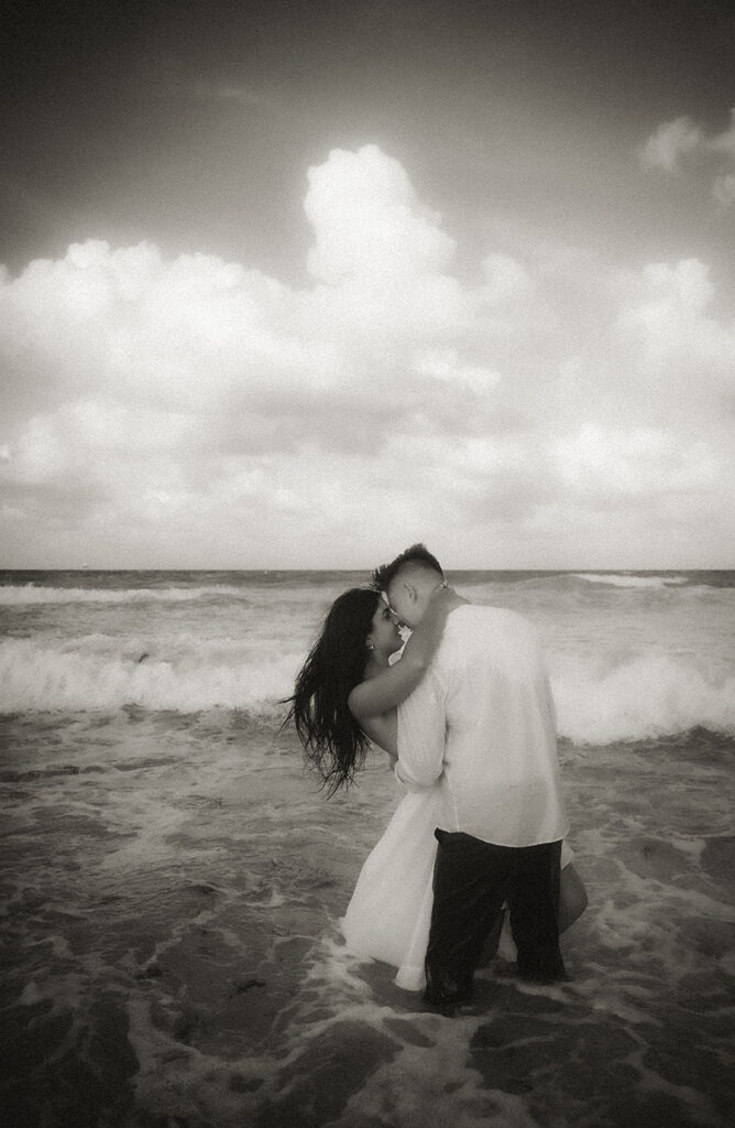 Couple face each other while standing in the ocean