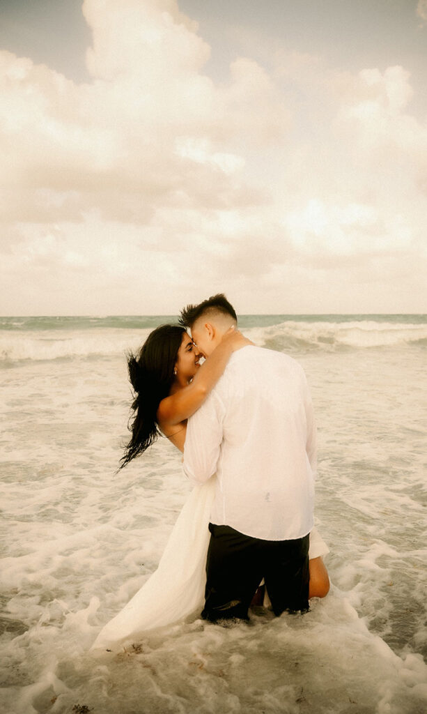 Couple face each other while standing in the ocean