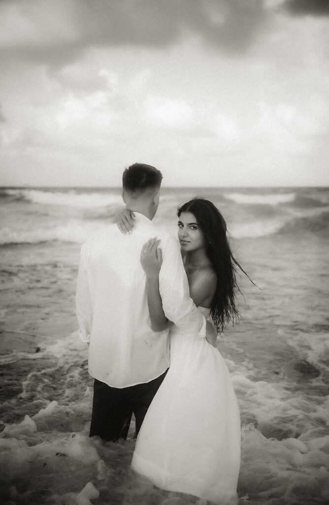 Couple face each other while standing in the ocean