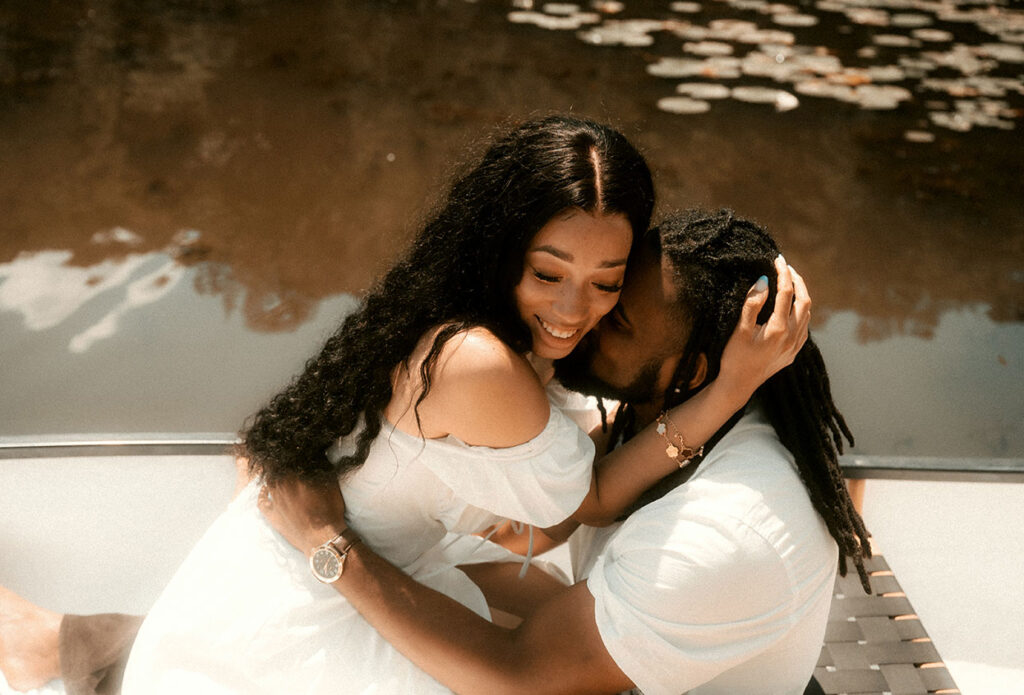 Couple embrace in a boat during their engagement photos