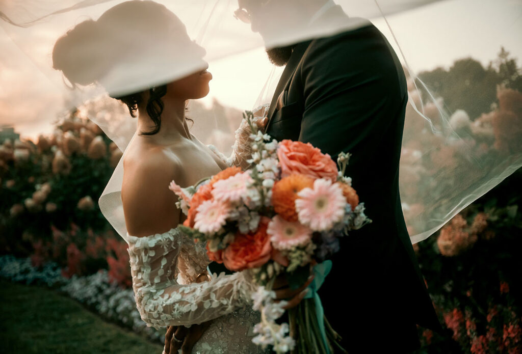 Bride and Groom against the sun and under the bride's veil at Phipps Wedding