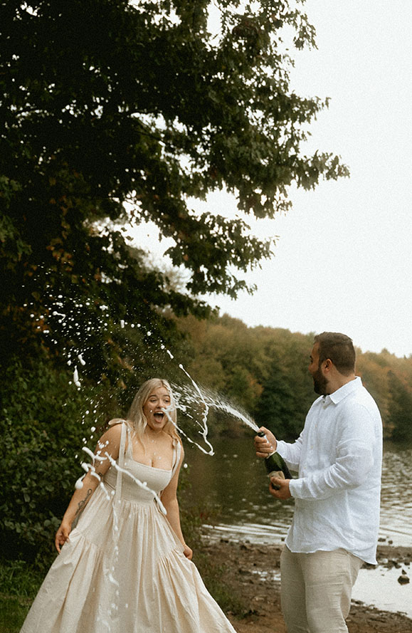 BW Couple pop Champagne bottle celebrating their engagement in Moraine