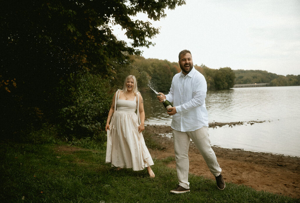 BW Couple pop Champagne bottle celebrating their engagement in Moraine State Park