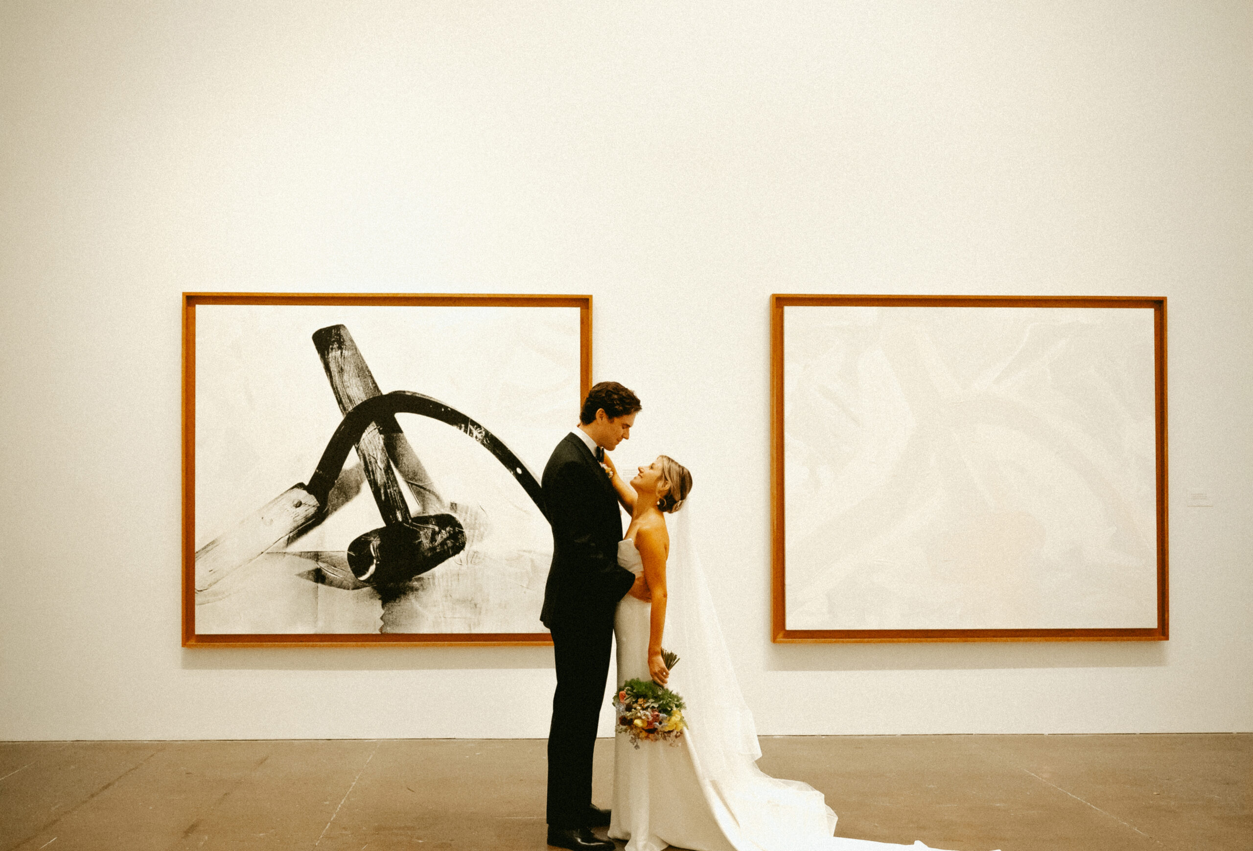 Bride and Groom stand between paintings at the Andy Warhol Museum