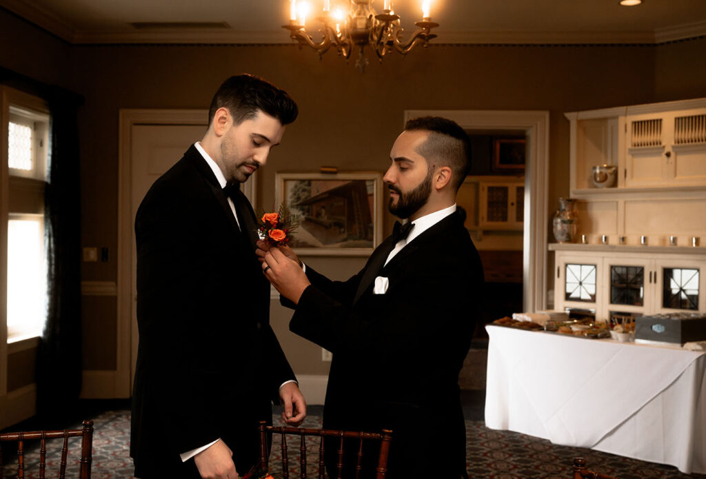 Groom Putting boutonnieres at Shelby Club Wedding