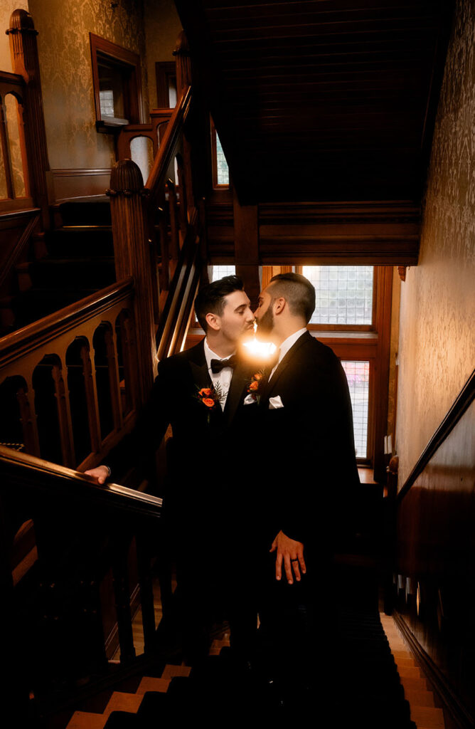 Couple kiss at Shelby Club Staircase during bridal photos