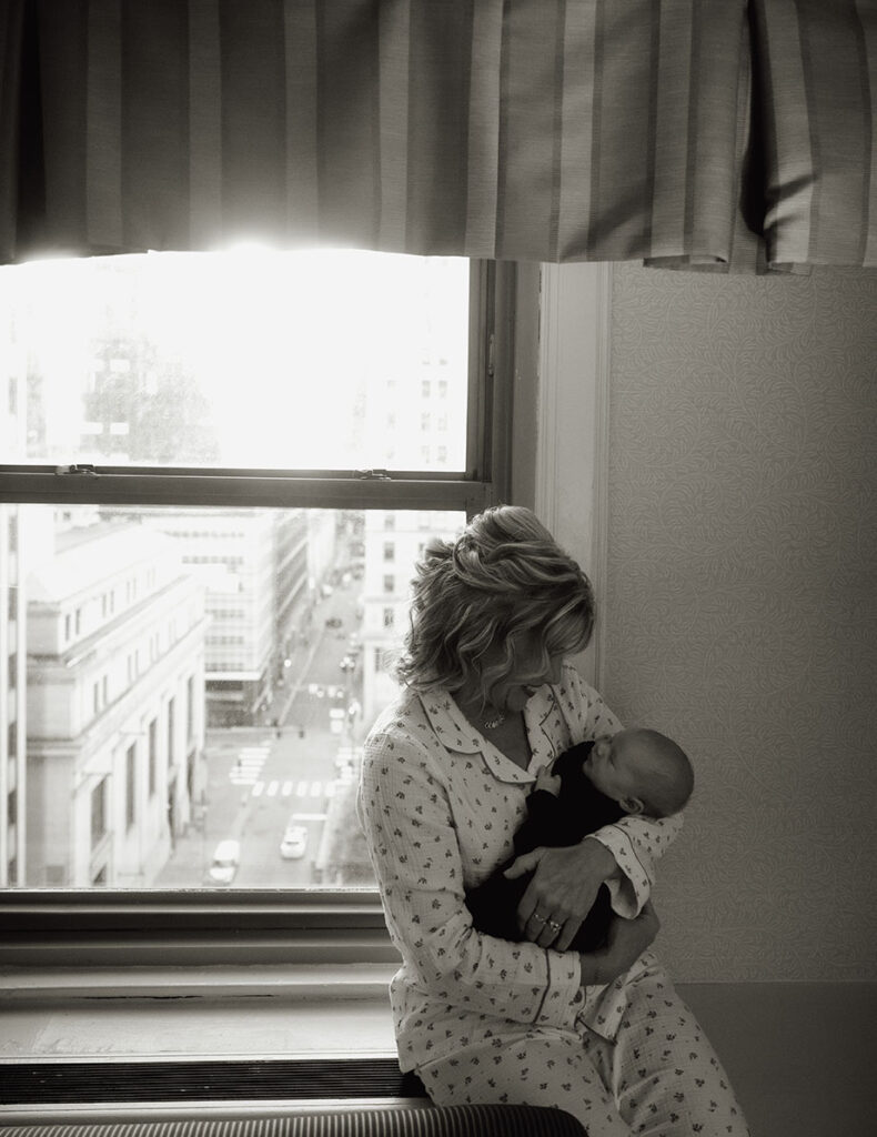 Mother of the Groom holding baby by window