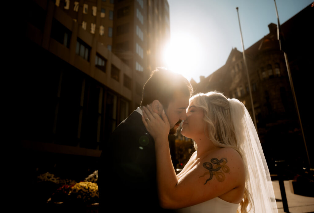 Bride and Groom against the sun about to kiss in Downtown Pittsburgh