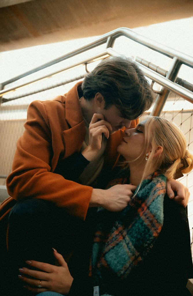 Couple Sitting in the staircase about to kiss during their engagement