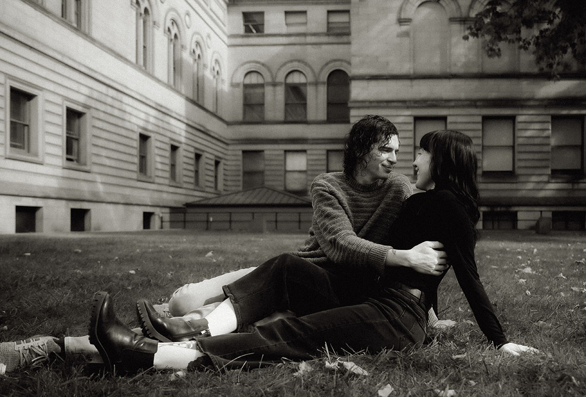 Couple embrace each other at Oakland Field during their Engagement