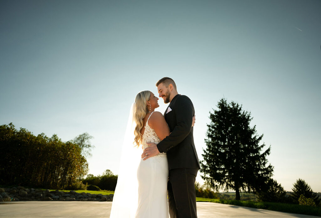 Bride and Groom facing each other against the blue sky