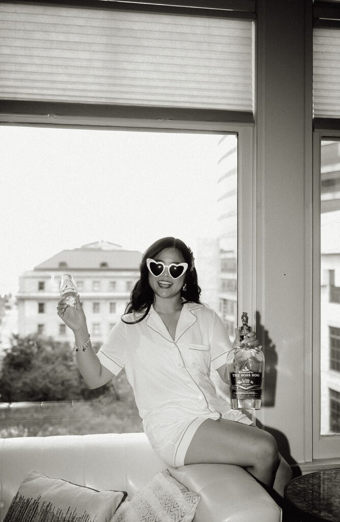 Bride holding a drink with white sunglasses on