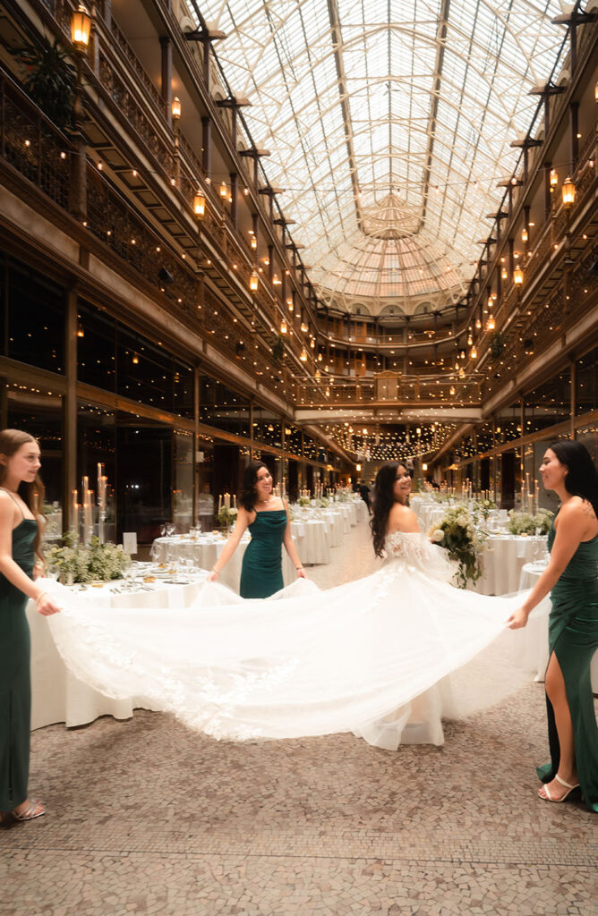 Bridesmaids holding bride's dress