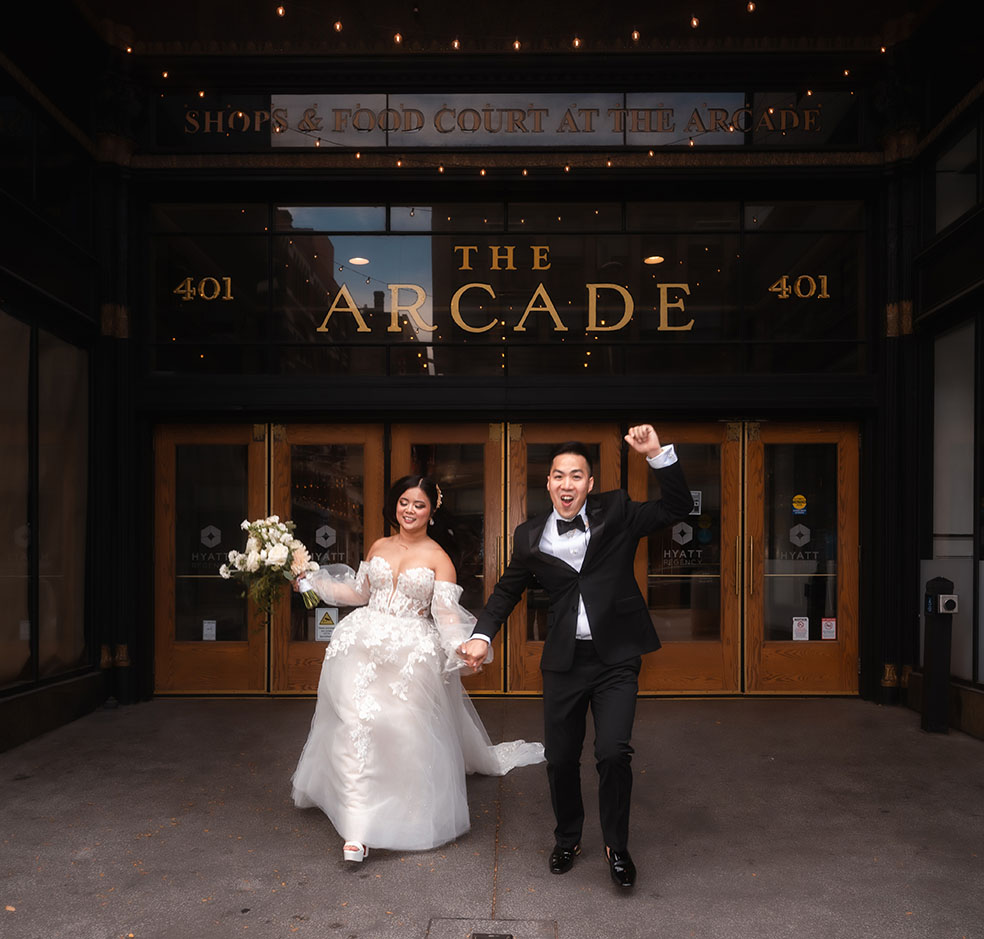 Bride and Groom Walking out of the Arcade