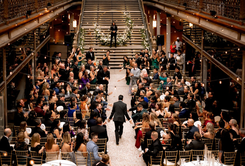 Groom walking down with guests looking