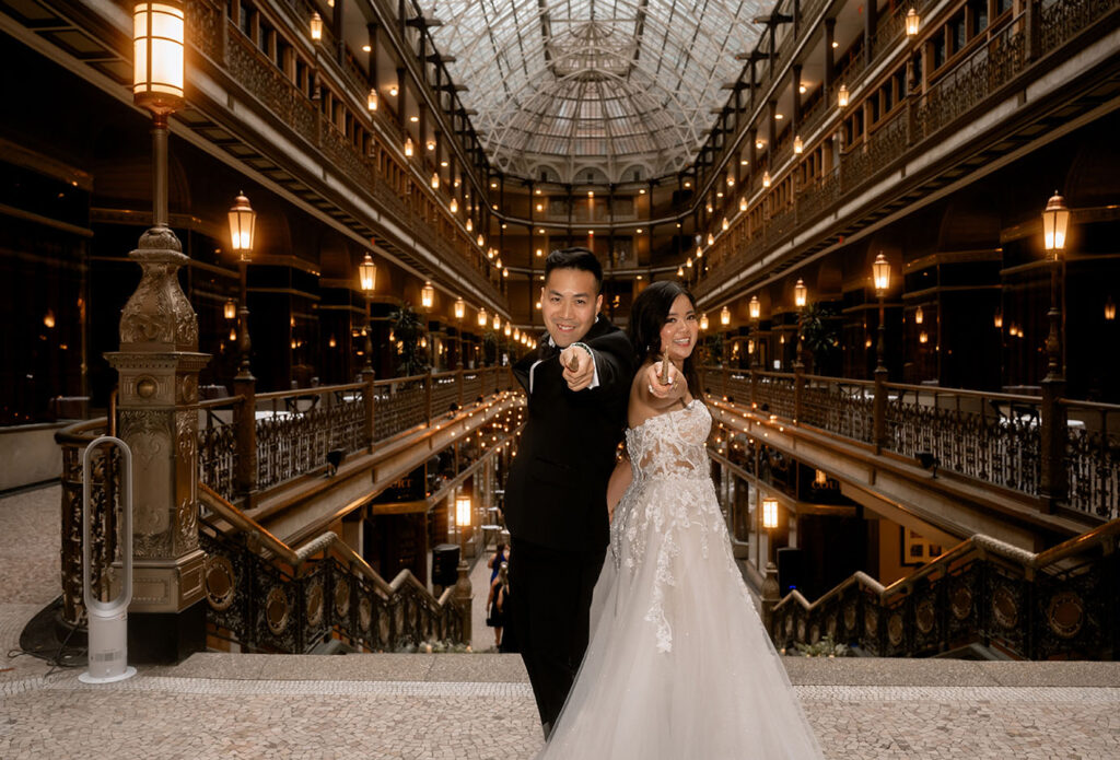 The Arcade Bride and Groom Pointing with their wands