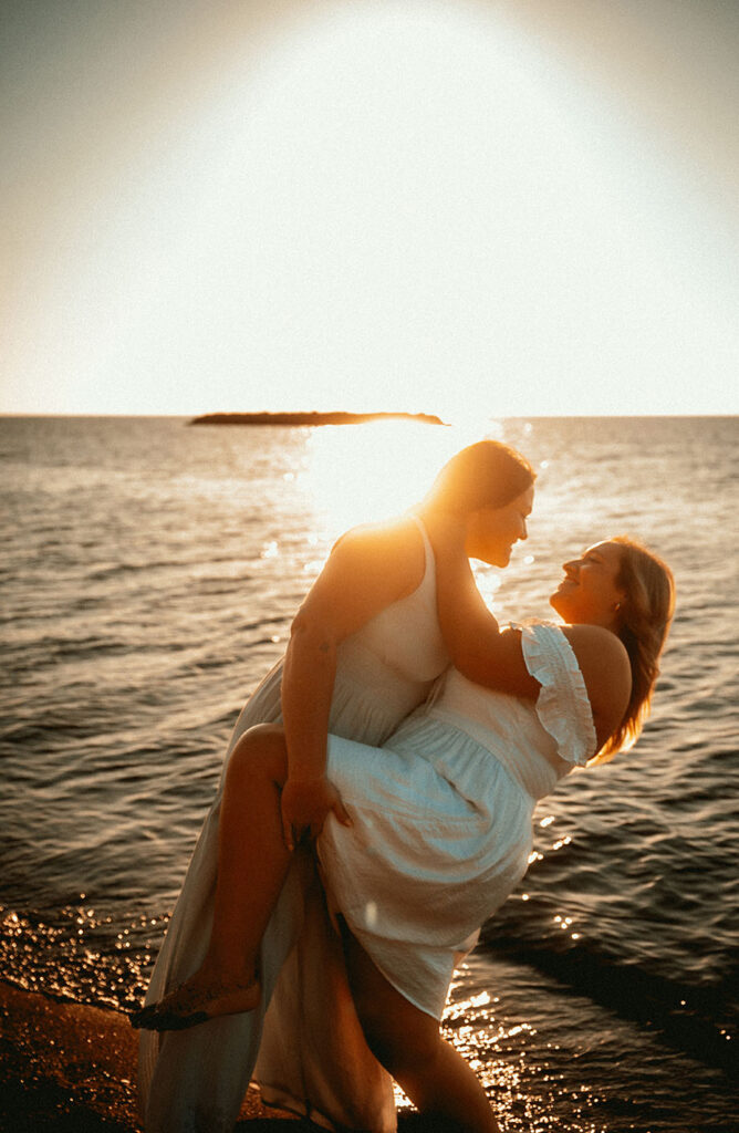 Same sex couple deeping during sunset at beach Engagement