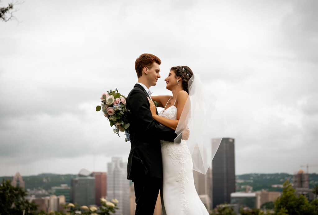 Bride and Groom Kiss at Emerald Park with Pittsburgh Skyline