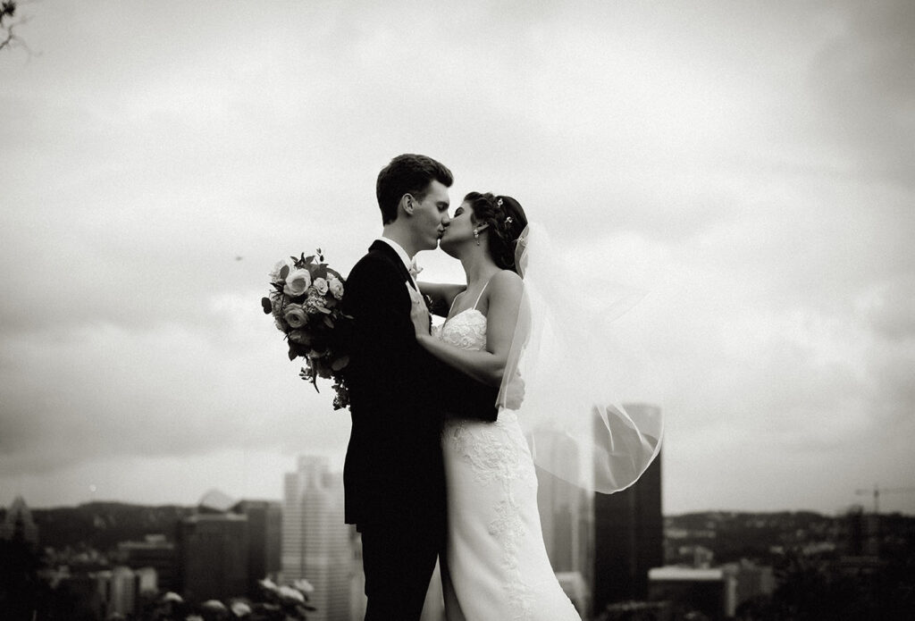 Bride and Groom Kiss at Emerald Park with Pittsburgh Skyline