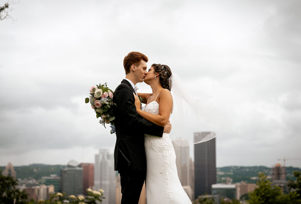 Bride and Groom Kiss at Emerald Park with Pittsburgh Skyline