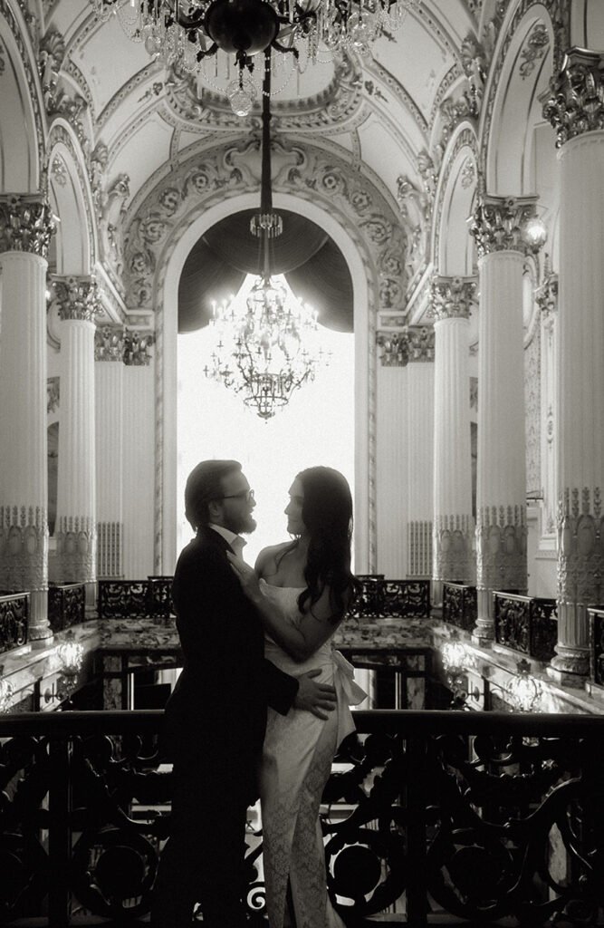 Couple standing on the grand staircase of Heinz Hall in formal attire during their engagement session in Pittsburgh.