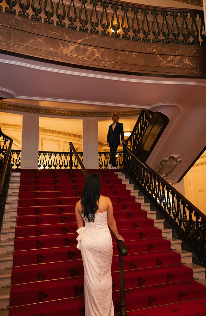 Couple looking at each other in the grand staircase at Heinz Hall.