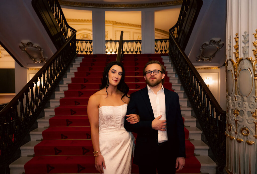 Romantic close-up of couple sharing a quiet moment in the red velvet theater seating at Heinz Hall.
