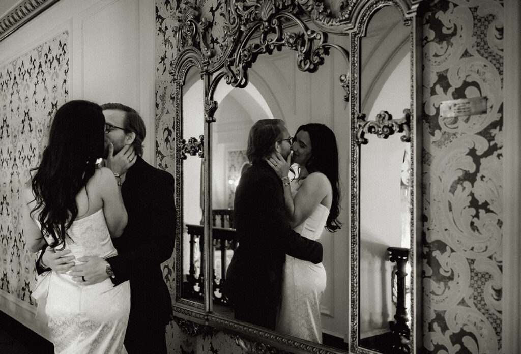 Editorial-style photo of groom-to-be adjusting his suit jacket in the mirror-lined hallway of Heinz Hall.