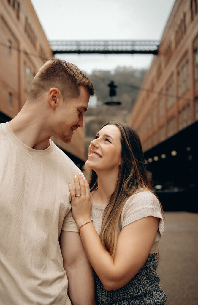 Intimate moment between couple during their rainy engagement session in Pittsburgh’s South Side.