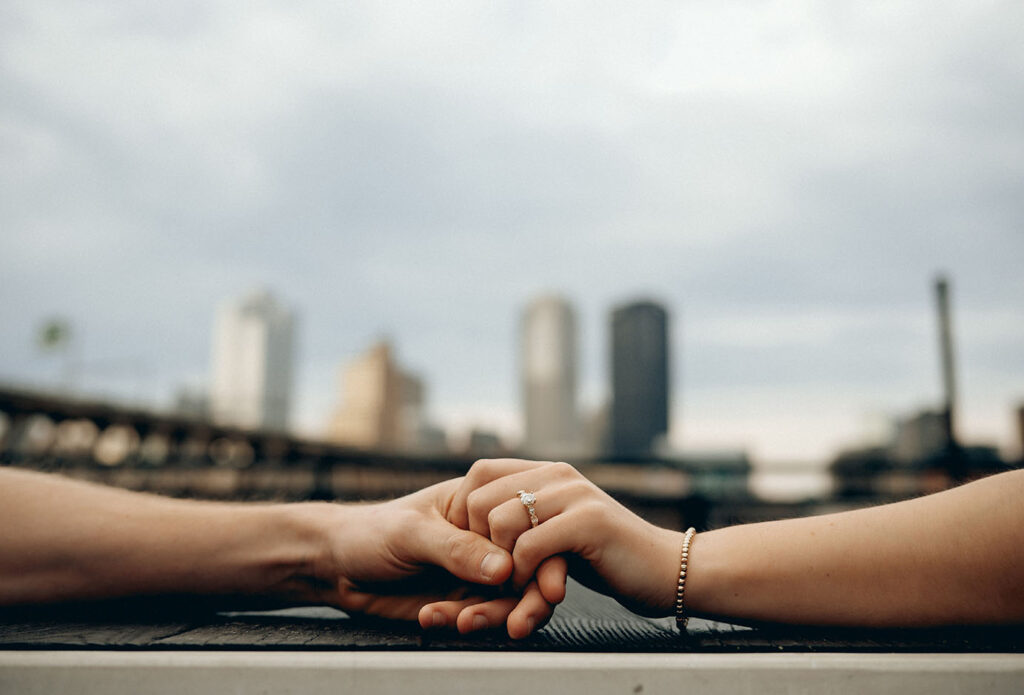 Close Up of engagement ring with Pittsburgh Skyline in the background at The Highline.