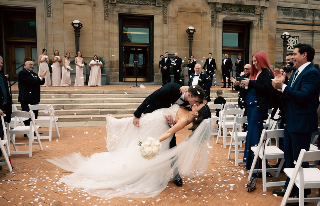 Bride and Groom kissing as they walk out of their ceremony at the Soldiers and Sailors in Oakland
