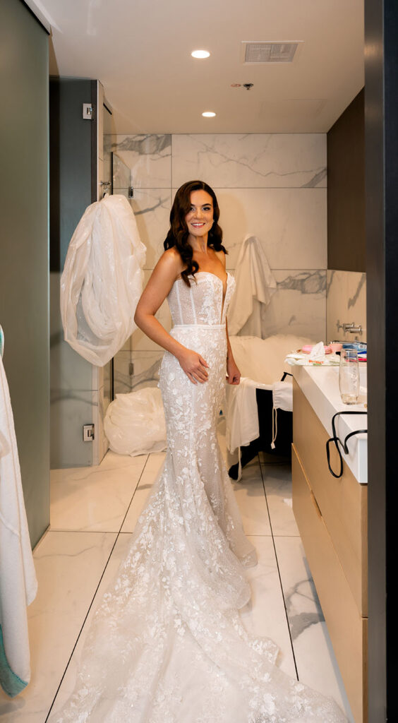 Bride finishing putting on her wedding gown at the Oaklander Hotel