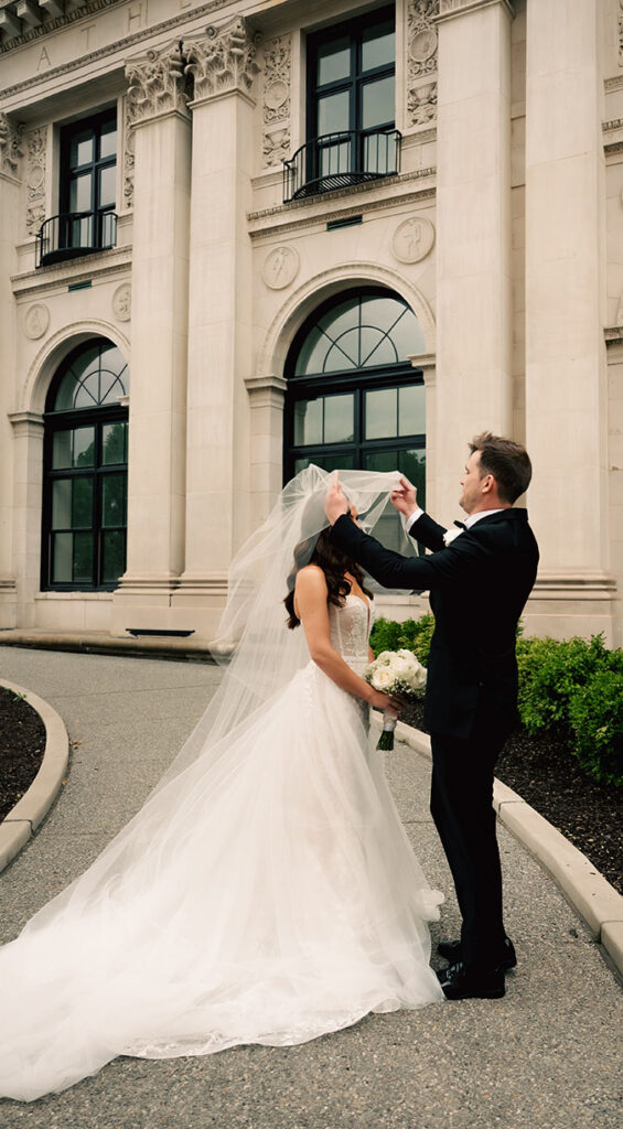Groom putting bride's veil down in Classy Oakland Wedding