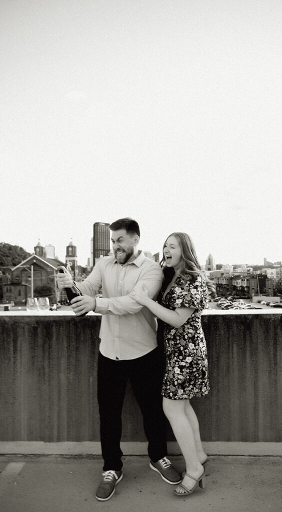 BW Couple popping champagne bottle in the strip district