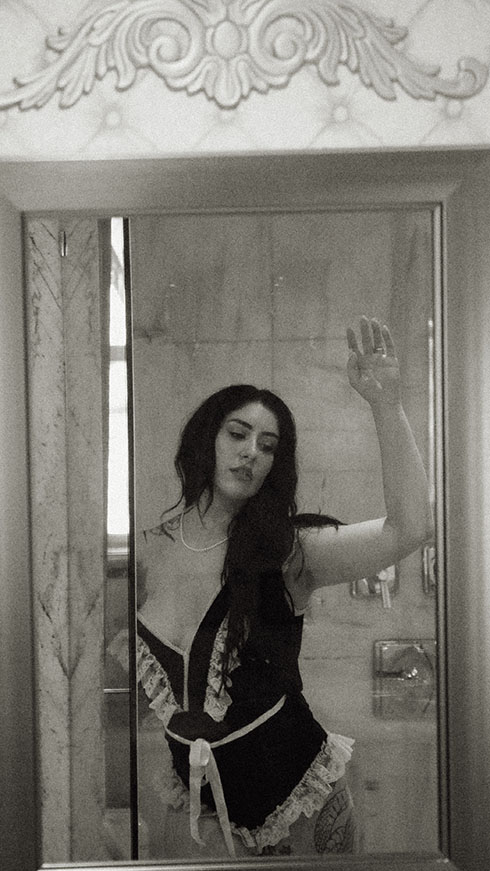 Woman holding hair during her boudoir photos at chateau connellsville