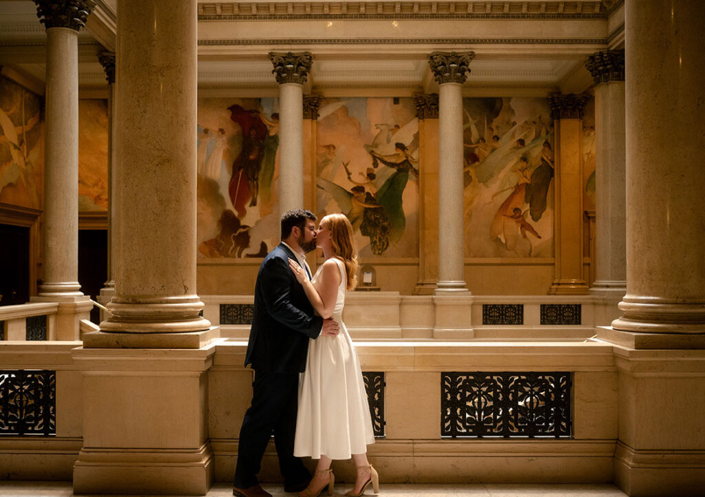 Couple stand in the grand staircase at Carnegie Museum of Art in Pittsburgh