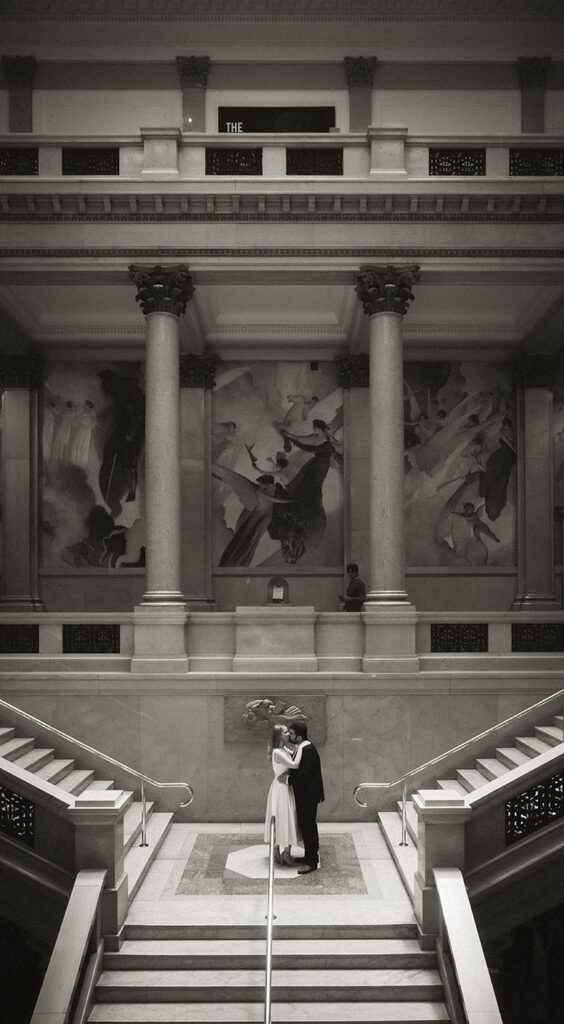 BW Couple stand in the grand staircase at Carnegie Museum of Art in Pittsburgh