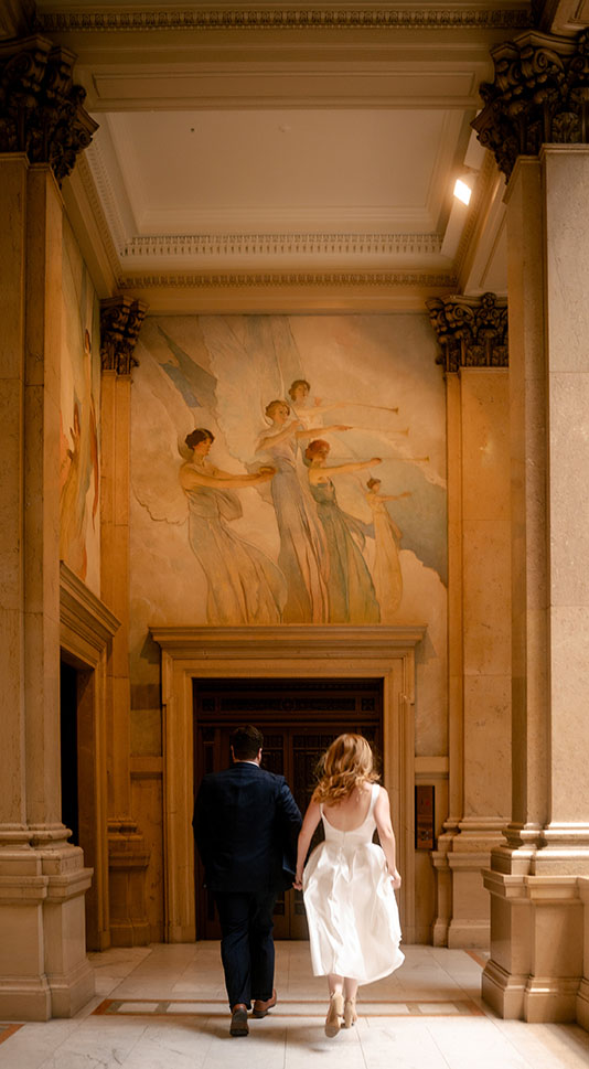 Couple run at the Hall of Sculpture in Carnegie Museum of Art in Pittsburgh