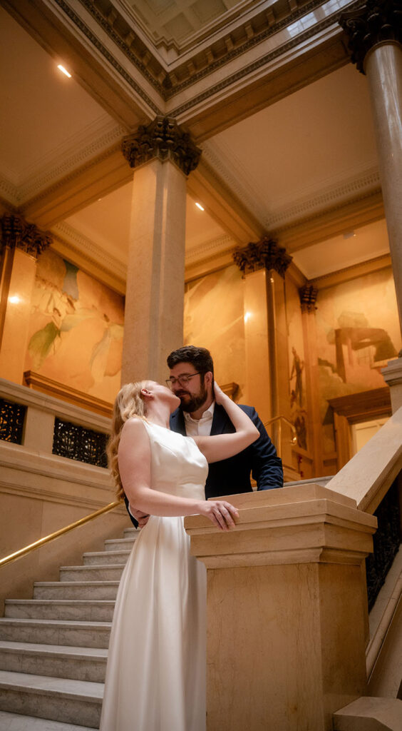 Couple kiss in the grand staircase at Carnegie Museum of Art in Pittsburgh