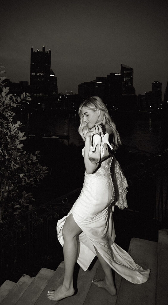 Bride walking down at night with Pittsburgh Skyline in the background