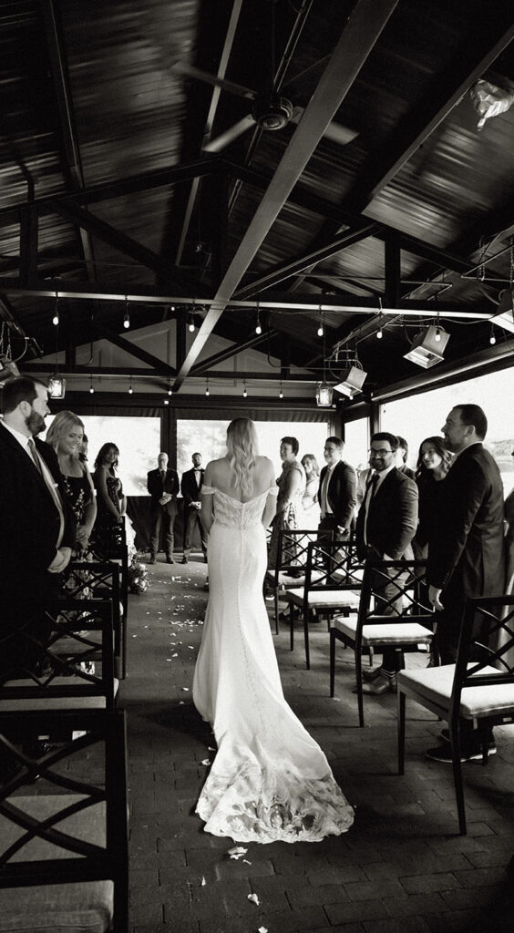 Bride walking down the aisle with all their guests looking at her