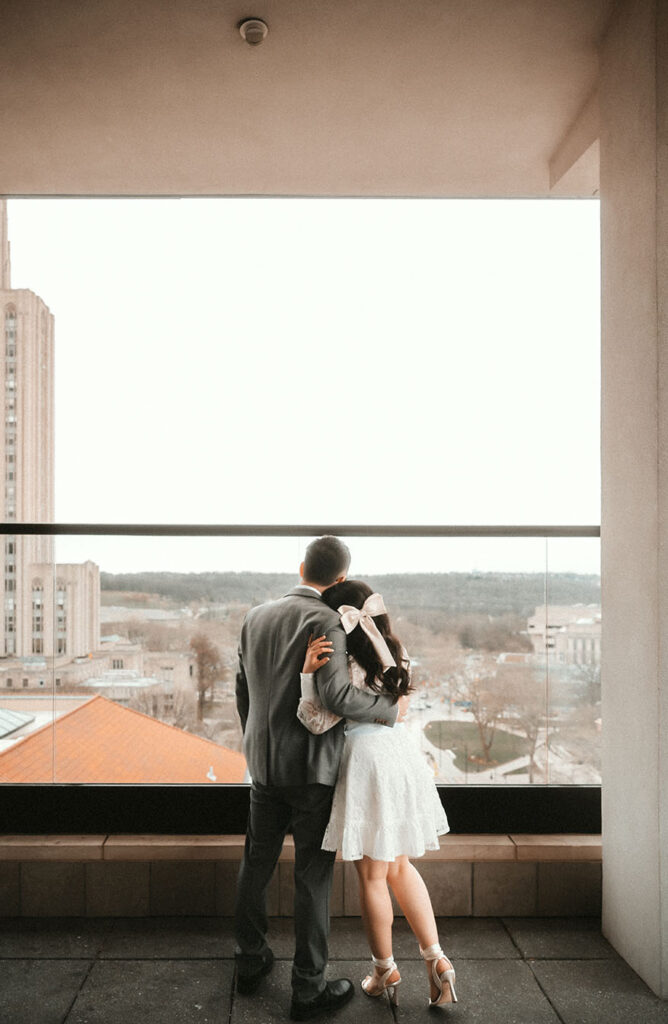 Couple looking at the Cathedral of Learning from The Oaklander's Patio