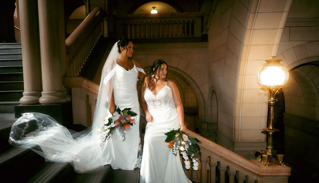 Bride and bride stand at the Allegheny County Courthouse before their wedding