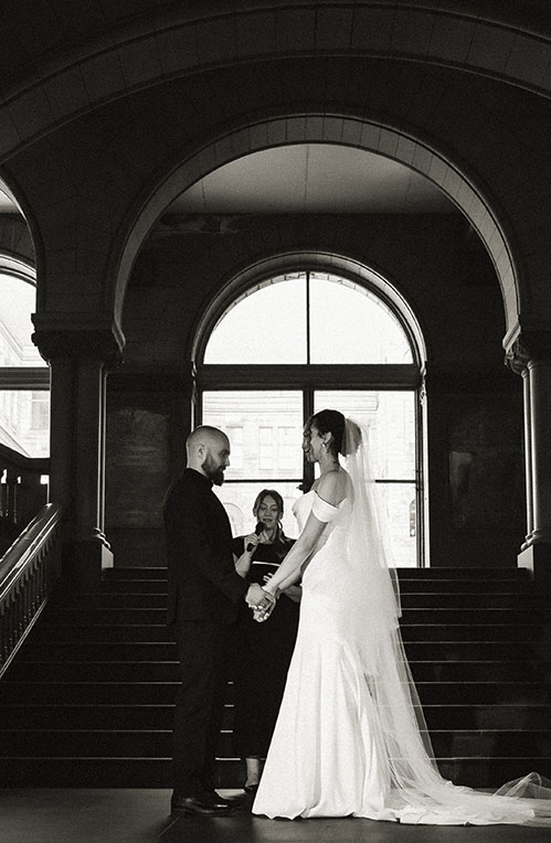 Bride and groom exchanging vows inside the Allegheny County Courthouse surrounded by family during their Pittsburgh elopement.