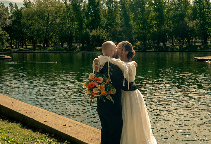 Newlyweds Kissing by the water at Allegheny Commons Park after their Pittsburgh courthouse elopement, surrounded by fall trees and golden light
